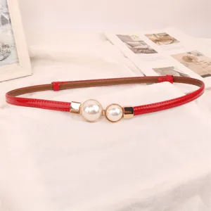 Detailed view of an elegant slim red belt featuring two white pearl decorations for women's dresses.