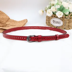 Red genuine leather hollowed belt detail shot, slim waist accessory for women fashion wear.