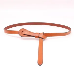 Vue détaillée de ceinture fine en cuir pour femme marron avec nœud élégant et stylé.