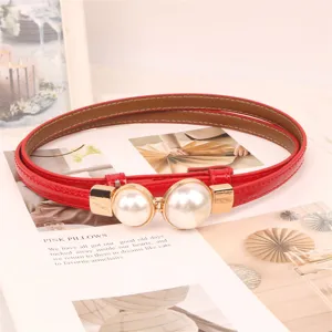 Detail of red elegant thin belt featuring a stylish double pearl buckle design.