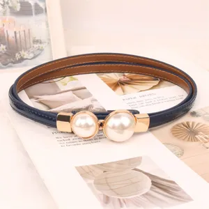 Detail view of an elegant navy blue thin belt for women featuring a large double pearl buckle