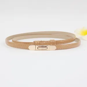 Smalle lakleren damesriem met metalen gesp, minimalistisch khaki taille accessoire detail.