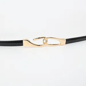 Smalle zwarte lakleer damesriem met stijlvolle gouden haakgesp als elegante jurkaccessoire.