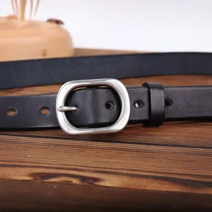 Genuine leather belt detail shot showing the metal pin buckle and premium black strap texture.