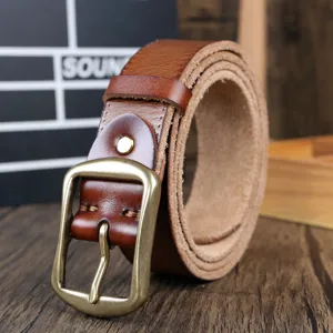 Details of genuine leather men belt with vintage brass buckle rolled on wood table.