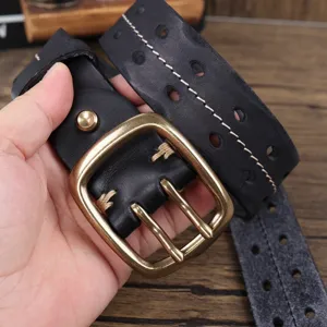 Primo piano di cintura da uomo in vera pelle nera retrò con fibbia in ottone a doppio ardiglione.