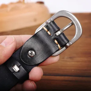 Close-up detail of genuine leather belt buckle with metal hardware and stitching craftsmanship.