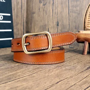 Detail shot of vintage genuine leather womens belt with retro brass metal buckle and stitching.