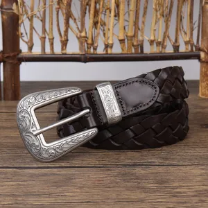Close-up of vintage dark brown braided leather belt with ornate silver buckle