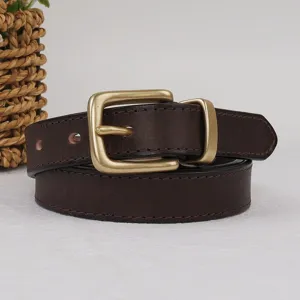 Gros plan détaillé de la ceinture en cuir marron foncé avec boucle en laiton vintage.