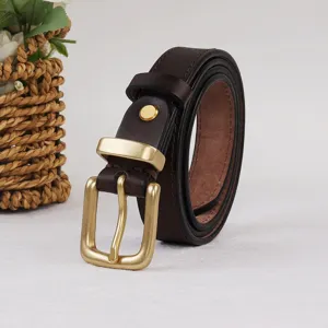 Gros plan détaillé du ceinturon en cuir marron avec boucle ardillon en laiton vintage.