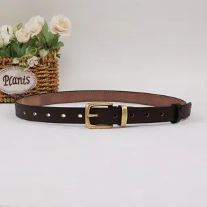 Gros plan détaillé d'une ceinture en cuir marron foncé rétro avec boucle en laiton.