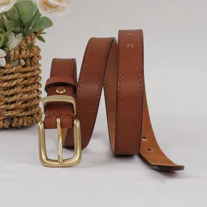 Gros plan sur une ceinture en cuir marron avec surface texturée et boucle ardillon rétro.