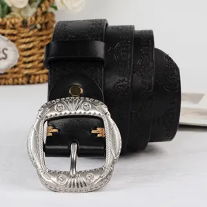 Detail of women's black embossed leather belt featuring an intricate silver-tone ornate metal buckle.