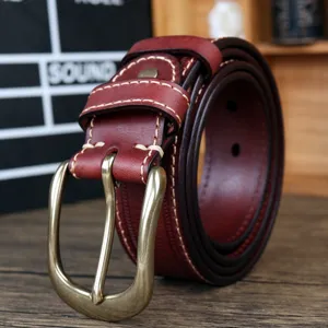 Détail de ceinture en cuir véritable pour homme avec coutures et boucle en laiton.