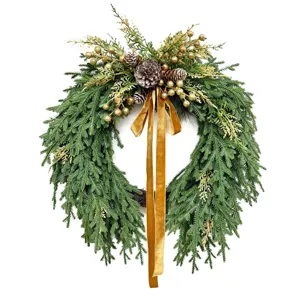 Detailed close-up of a Norfolk pine Christmas wreath with golden berries and ribbon
