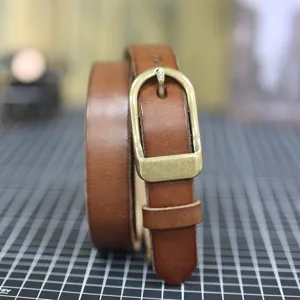 Detailed view of women's narrow genuine leather belt featuring a classic vintage metal buckle.