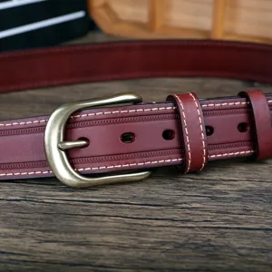 Détail en gros plan de ceinture en cuir vintage pour homme avec boucle en métal et couture.