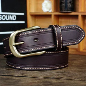 Vue détaillée d'une ceinture en cuir marron rétro avec boucle ardillon en laiton sur bois.