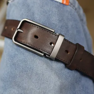 Dettaglio della cintura uomo in vera pelle vintage con fibbia ad ardiglione in metallo.