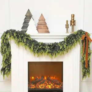 Lush faux Norfolk pine garland draped over a cozy white mantel with a warm fireplace display.