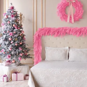 Pink Norfolk pine garland and wreath decorating a cozy holiday bedroom scene.