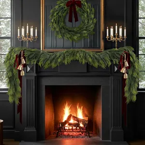 Realistische Norfolk-Kiefer Weihnachtsgirlande mit roten Schleifen und Glocken am Kamin