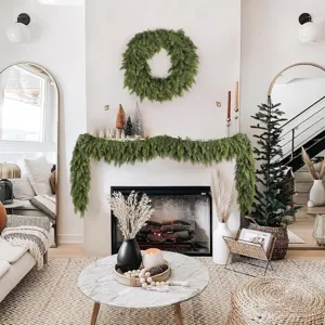 Natural look artificial Norfolk pine garland draped over a modern fireplace mantel