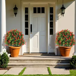 Pair of lush artificial boxwood topiary balls with red roses decorating a house entrance