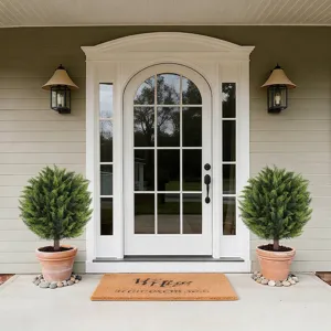 Pair of lush artificial cedar topiary trees in pots decorating a classic house front porch