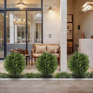 Three lifelike artificial cedar topiary balls decorating a modern outdoor patio.