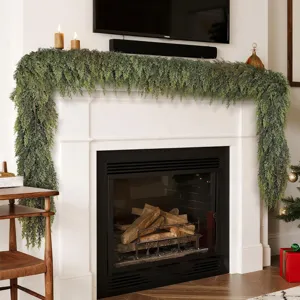 Lush Norfolk pine garland draped over a white fireplace mantle for Christmas decor