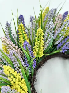 Detailaufnahme eines bunten künstlichen Blumenkranzes für die Frühlingsdekoration an Türen