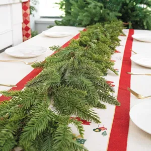 Nahaufnahme einer lebensechten Norfolk-Kiefer-Girlande auf einem Weihnachtstisch.