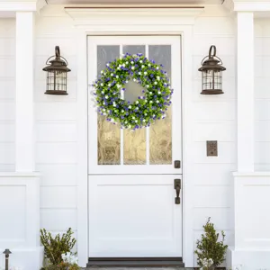 Detailed view of a spring floral wreath hanging on a white wooden front door