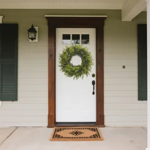 Lush green artificial cedar wreath decorating a classic white front door porch