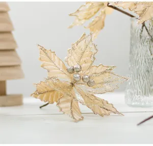 Primo piano di un fiore di Natale in velluto champagne da 20cm con glitter e bacche d'argento.