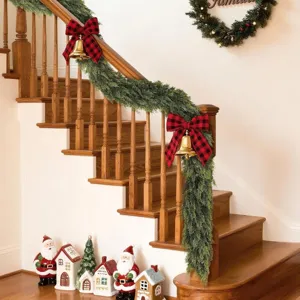 Detailed view of soft-touch artificial Norfolk pine garland draped on a wooden staircase.