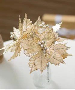 Dettaglio di poinsettia di Natale in velluto champagne con bordi glitter e bacche