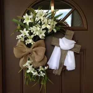 Detailed view of a religious Easter wreath with white lilies and a wooden cross