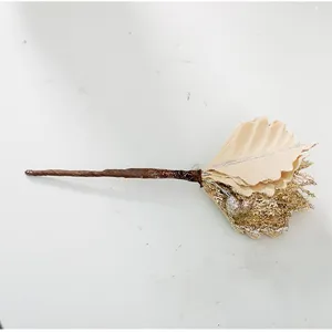 Dettaglio di un ramo di fiore natalizio fatto a mano in velluto champagne con glitter dorati lucidi