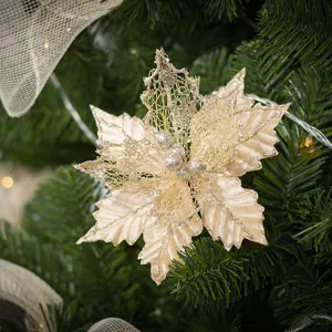 Fiore di stella di Natale scintillante color champagne su albero verde