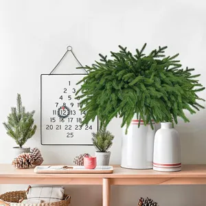 Üppige künstliche Norfolk-Kiefernzweige in eleganter weißer Vase für Weihnachten.