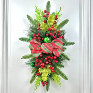 Christmas staircase swag with plaid bow, red berries, pine branches, and green ornaments