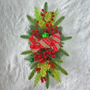 Detailed view of festive Christmas stair swag with red plaid bow and berries