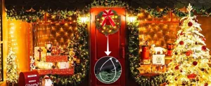 Detail showing the hanging mechanism of a lighted Christmas wreath on a red front door
