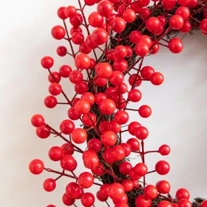 Macro detail of a festive red berry Christmas wreath on a natural twig base decoration