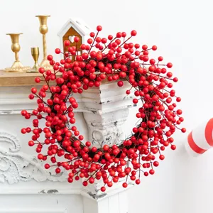 Vibrant red berry Christmas wreath displayed on an elegant white vintage fireplace mantel