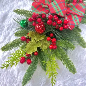 Close-up of Christmas teardrop swag with red berries and plaid bow detail.