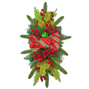 Festive Christmas swag with red plaid bow, berries and pine needles for decor